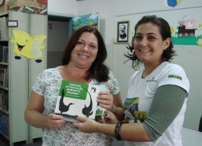 Cynthia Ranieri, assistente de Educa&ccedil;&atilde;o Ambiental do Projeto, entregando cartilha &agrave; escola Padre Leonardo Nunes