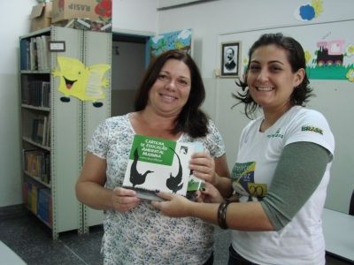 Cynthia Ranieri, assistente de Educa&ccedil;&atilde;o Ambiental do Projeto, entregando cartilha &agrave; escola Padre Leonardo Nunes