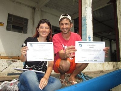 Cassiane Tatsch, estagi&aacute;ria do Projeto Albatroz, entregando certificado de capacita&ccedil;&atilde;o ao pescador