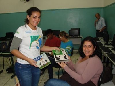 Cynthia Ranieri, do Projeto Albatroz, entrega cartilhas &agrave; professora da escola municipal Martins Fontes